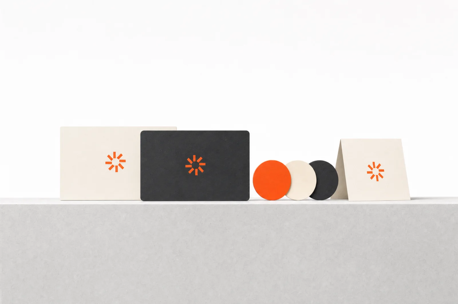 Marken-Set von NUVO Studio auf einem Betonsockel: Visitenkarten mit Logo-Marke und Farbchips